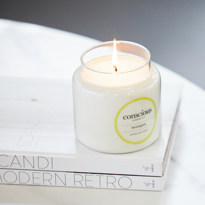 Large natural Lemongrass scented soy candle sitting on scandi Modern Books and white marble coffee table